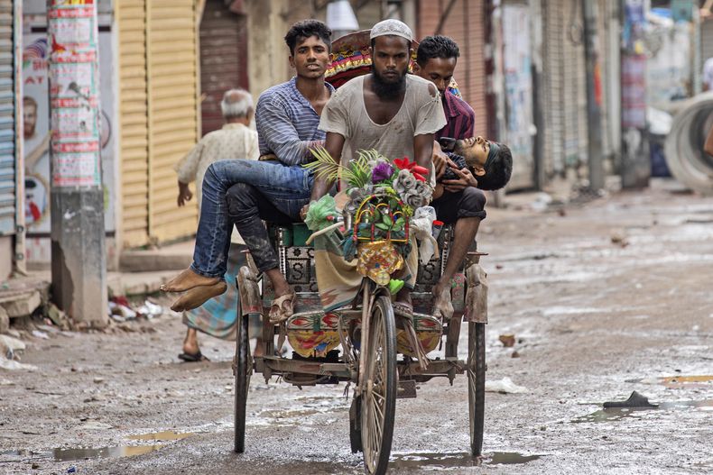 ARCHIVO - Gente lleva a un manifestante herido en un rickshaw con bicicleta después de que fuera baleado por la policía en una protesta contra la primera ministra, Sheikh Hasina, y su gobierno, en Daca, Bangladesh, el 5 de agosto de 2024. (AP Foto/Rajib Dhar, Archivo)