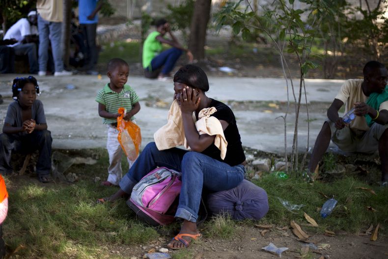 Una mujer y sus hijos esperan el domingo 24 de noviembre de 2013 en un refugio a ser llevados a su pueblo natal junto con otros haitianos despu&eacute;s de ser deportada por las autoridades dominicanas. Los mandatarios de las naciones caribe&ntilde;as sos