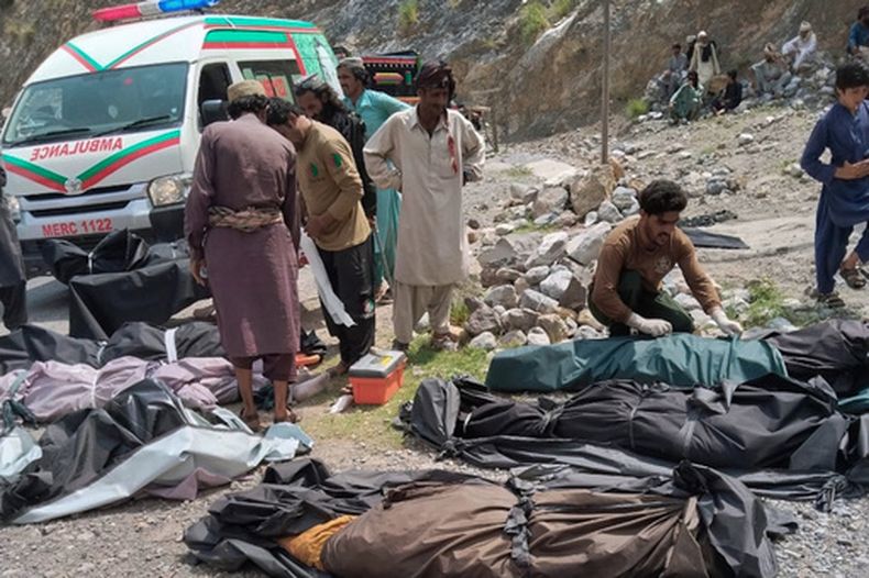 Rescatistas y voluntarios cubren cuerpos después de que un autobús de pasajeros atestado cayó a un barranco, en Dana Sar, en el suroeste de Pakistán, el 3 de julio de 2026. (Foto AP/Zain Ullah)