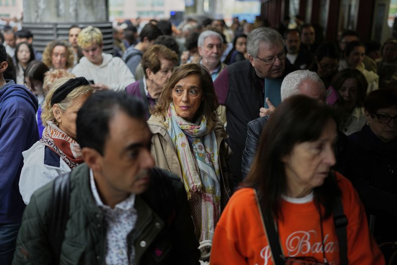 Viajeros esperan en el andén a tener noticias sobre sus trenes retrasados en una estación de ferrocarril en Madrid, España, el lunes 5 de mayo de 2025. (AP Foto/Manu Fernández)