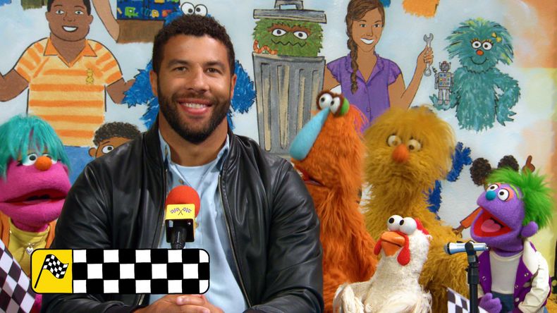 Esta imagen, publicada por Sesame Workshop, muestra a Bubba Wallace con varios personajes de los Muppets en el plató de Plaza Sésamo. (Sesame Workshop/Netflix via AP)