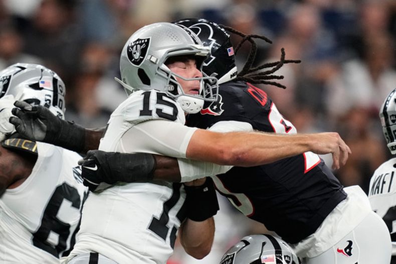 Fernando Mendoza, quarterback de los Raiders de Las Vegas, es golpeado por Jadeveon Clowney, ala defensiva de los Texans de Houston, en un partido de pretemporada realizado el jueves 20 de agosto de 2026 (AP Foto/Ashley Landis)