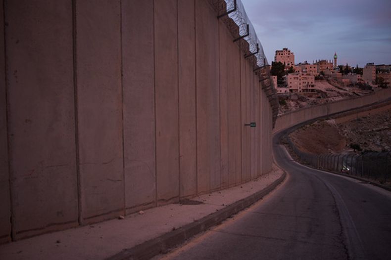 El minarete de una mezquita y varios edificios de la localidad cisjordana de Abu Dis, vistos desde detrás del muro de separación construido por Israel cerca de Jerusalén, el 5 de octubre de 2026. (AP Foto/Leo Correa)