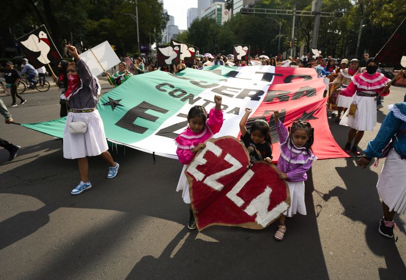 Simpatizantes del Ejército Zapatista de Liberación Nacional lanzan proclamas contra el presidente de México, Andrés Manuel López Obrador, en una marcha de protesta por la reciente ola de violencia que azota al estado mexicano de Chiapas, en donde siete indígenas fueron asesinados por paramilitares, en Ciudad de México el jueves 8 de junio de 2023. (AP Foto/Fernando Llano)