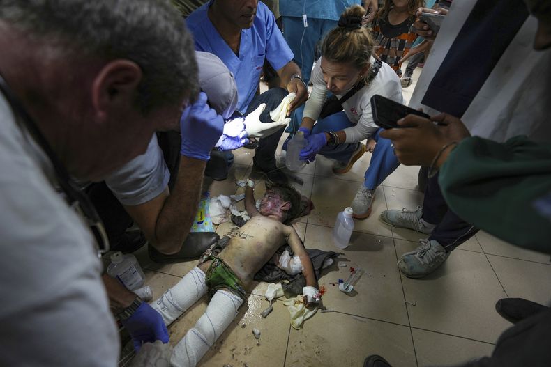 Médicos atienden a un niño herido por un bombardeo israelí en el campo de refugiados de Nuseirat, en el hospital Mártires de al-Aqsa en Deir al Balah, el sábado 29 de octubre de 2024, en el centro de la Franja de Gaza. (AP Foto/Abdel Kareem Hana)