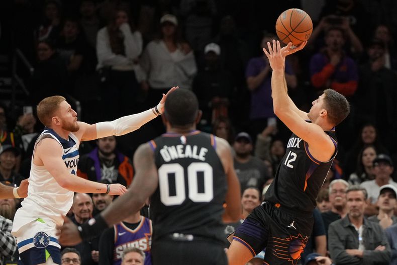 Collin Gillespie (12), de los Suns de Phoenix, dispara el tiro ganador frente a los Timberwolves de Minnesota, durante la segunfa mitad del juego de baloncesto de la Copa NBA, el viernes 21 de noviembre de 2025, en Phoenix. (AP Foto/Rick Scuteri)