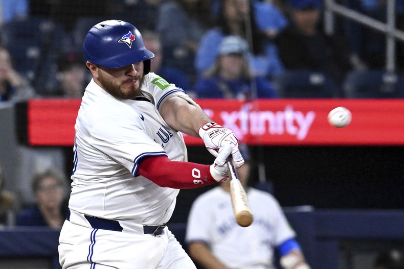 Alejandro Kirk (30), de los Azulejos de Toronto, batea un cuadrangular de tres carreras frente a los Rays de Tampa Bay en la sexta entrada del partido de béisbol de Grandes Ligas el miércoles 14 de mayo de 2025, en Toronto. (Jon Blacker/The Canadian Press vía AP)