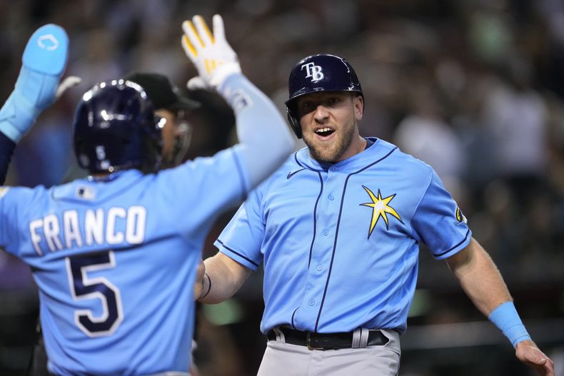 Los jugadores de los Rays de Tampa Bay Luke Raley y Wander Franco (5) celebran tras anotar en un doble de Josh Lowe en el noveno inning de un juego de la MLB contra los Diamondbacks de Arizona, el 28 de junio de 2023, en Phoenix. (AP Foto/Matt York)