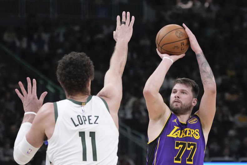 Luka Doncic, de los Lakers de Los Ángeles, dispara a Brook López, de los Bucks de Milwaukee, durante la primera mitad de un partido de baloncesto de la NBA, el jueves 13 de marzo de 2025, en Milwaukee. (AP Foto/Morry Gash)