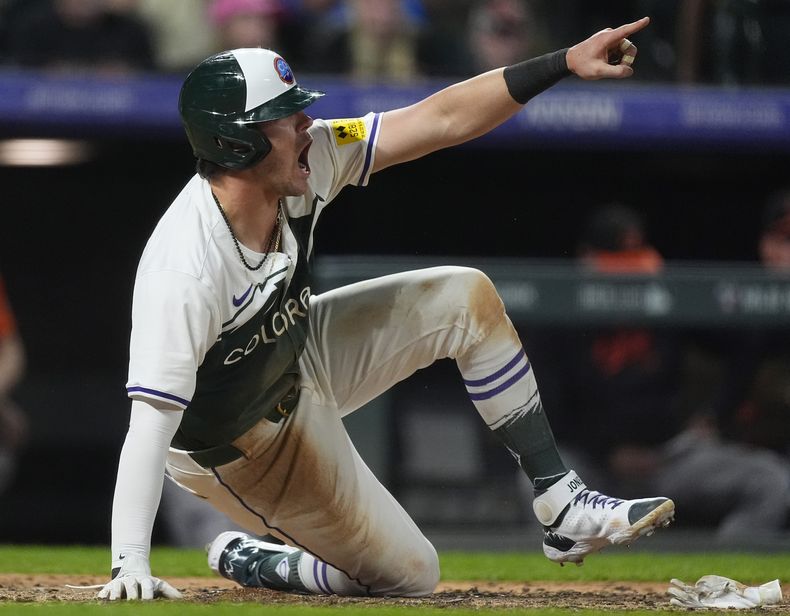 Nolan Jones, de los Rockies de Colorado, festeja tras anotar la carrera de la ventaja ante los Orioles de Baltimore, el sábado 31 de agosto de 2024 (AP Foto/David Zalubowski)