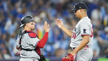 El dominicano Jhoan Durán, relevista de los Mellizos de Minnesota, festeja con el puertorriqueño Christian Vázquez, tras el duelo ante los Azulejos de Toronto, el viernes 9 de junio de 2023 (Mark Blinch/The Canadian Press via AP