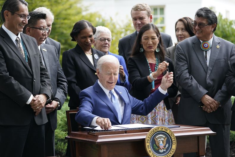 ARCHIVO - El presidente Joe Biden entrega un bolígrafo a la secretaria del Interior, Deb Haaland, mientras firma una proclamación en el jardín norte de la Casa Blanca en Washington, el 8 de octubre de 2021. (AP Foto/Susan Walsh, Archivo)