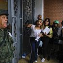 Un oficial de la Guardia Nacional se dirige a los votantes que hacen fila en la Escuela Andrés Bello mientras los observadores electorales de la oposición argumentan que no se les permite ingresar al centro de votación durante las elecciones presidenciales en Caracas, Venezuela, el domingo 28 de julio de 2024. (AP Foto/Cristian Hernández)