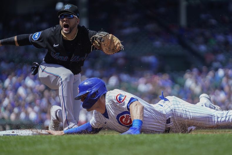 Nico Hoerner, de los Cachorros de Chicago, vuelve a la inicial, cubierta por el cubano Yuli Gurriel, de los Marlins de Miami, en el juego del viernes 5 de mayo de 2023 (AP Foto/Erin Hooley)