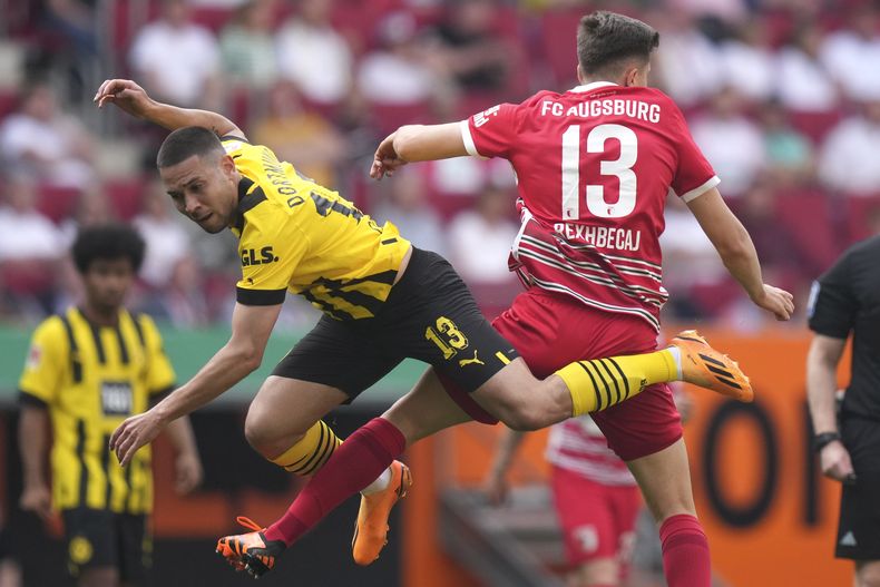 ARCHIVO - Foto del 21 de mayo del 2023, Raphael Guerreiro del Borussia Dortmund pelea por el balón con Elvis Rexhbecaj del Augsburg en el encuentro de la Bundesliga. El viernes 23 de junio del 2023, Guerreiro firma con el Bayern Munich. (AP Foto/Matthias Schrader, Archivo)