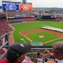 Fanáticos platican mientas que una cuadrilla de trabajadores de los Rojos de Cincinnati cubren el diamante durante el retraso por lluvia previo al partido contra los Guardianes de Cleveland, el lunes 27 de julio de 2026, en Cincinnati. (AP Foto/Kareem Elgazzar)