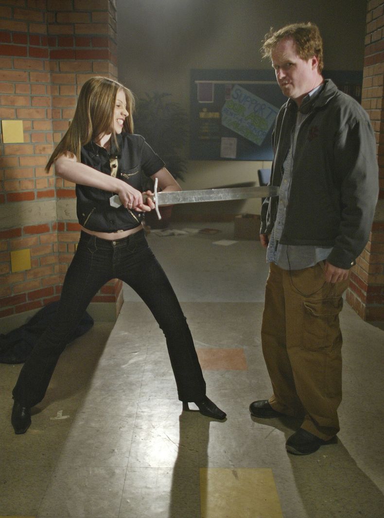 ARCHIVO - La actriz Michelle Trachtenberg, izquierda, que interpreta a Dawn, la hermana de Buffy Emmy, juega con el productor y creador de la serie Joss Whedon, durante la grabación del episodio final de Buffy the Vampire Slayer en Santa Mónica, California, el 16 de abril de 2003. (Foto AP/Damian Dovarganes, archivo)