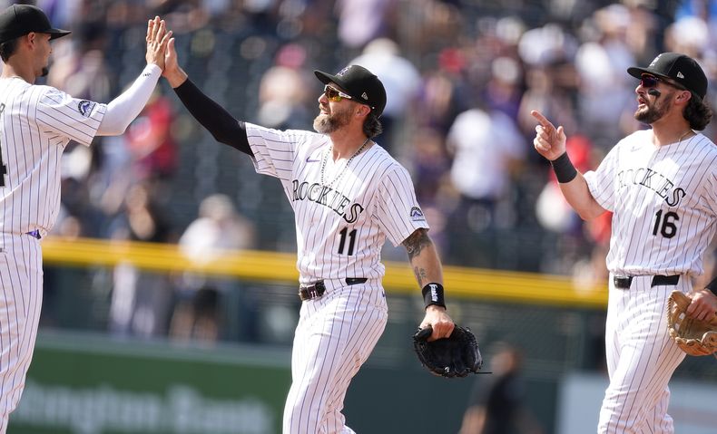 De izquierda a derecha, el campocorto de los Rockies de Colorado Ezequiel Tovar, el jardinero derecho Jake Cave y el jardinero central Sam Hilliard celebran después de derrotar a los Bravos de Atlanta el domingo 11 de agosto de 2024, en Denver. (AP Foto/David Zalubowski)