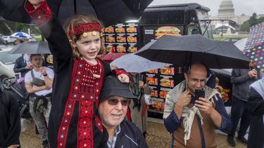 Una niña de 7 años de Springfield, Virginia, que viste un atuendo tradicional, levanta el puño en brazos de su abuelo, de origen palestino, en una manifestación propalestina, el sábado 18 de mayo de 2024, en el National Mall, cerca del Capitolio, en Washington. (AP Foto/Jacquelyn Martin)