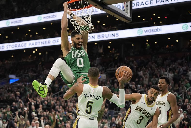 Jayson Tatum (0), de los Celtics de Boston, grita después de clavar ante Dejounte Murray (5), CJ McCollum (3) y Trey Murphy III (25), de los Pelicans de Nueva Orleans, durante la segunda mitad de un partido, el domingo 12 de enero de 2025, en Boston. (AP Foto/Robert F. Bukaty)
