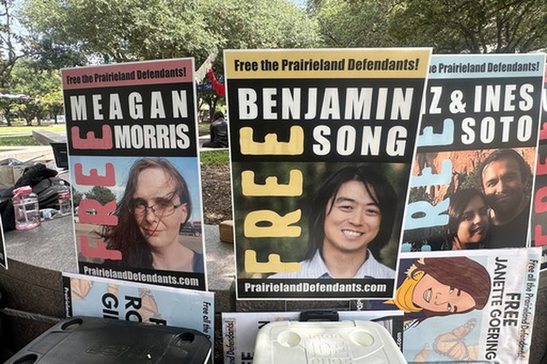 Manifestantes con retratos de personas acusadas por el tiroteo frente a un centro de detención de inmigrantes, frente a los tribunales en Fort Worth, Texas, el 23 de junio del 2026. (AP foto/Kendria LaFleur)