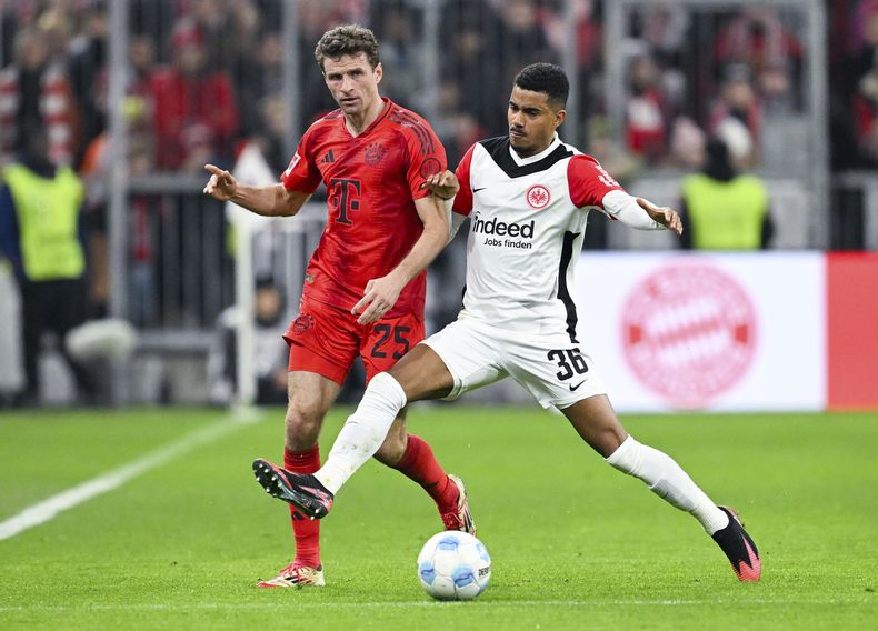 Thomas Muller del Bayern Munich y Ansgar Knauff del Eintrachr Frankfurt pelean por el balón en un encuentro de la Bundesliga el domingo 23 de febrero del 2025. (Sven Hoppe/dpa via AP)
