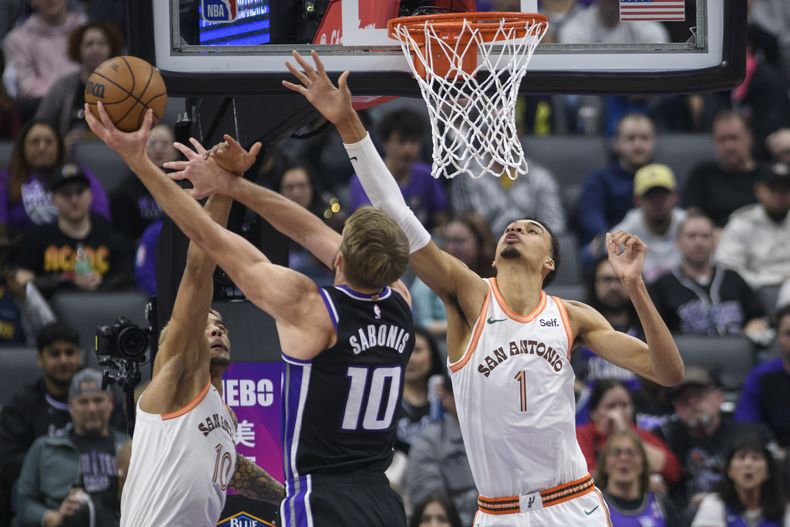 El lituano Domantas Sabonis, de los Kings de Sacramento, dispara frente a Jeremy Sochan, de los Spurs de San Antonio, en el partido del jueves 22 de febrero de 2024 (AP Foto/Randall Benton)