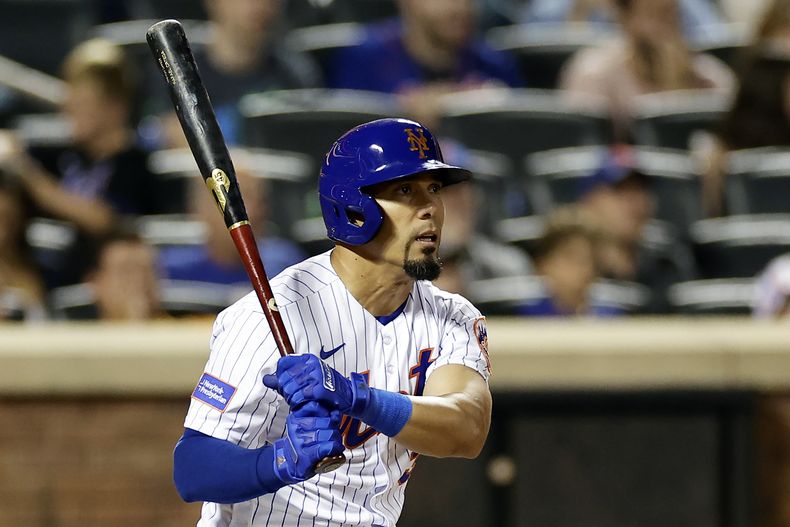 Rafael Ortega de los Mets de Nueva York pega un sencillo remolcador en la quinta entrada ante los Bravos de Atlanta el domingo 13 de agosto del 2023. (AP Foto/Adam Hunger)