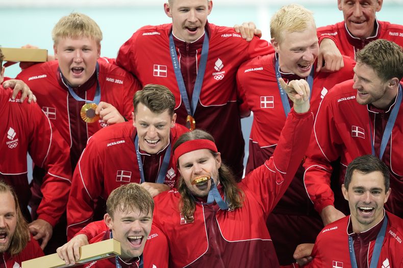 Los integrantes del equipo de Dinamarca de balonmano posan con la medalla de oro durante la ceremonia de premiación después de la final en la que Dinamarca superó a Alemania por el primer lugar en los Juegos Olímpicos, el domingo 11 de agosto de 2024, en Villeneuve-dAscq, Francia. (AP Foto/Aaron Favila)