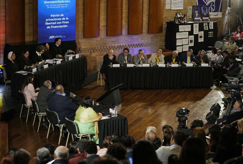 ARCHIVO - Ex comandantes de las Fuerzas Armadas Revolucionarias de Colombia (FARC), arriba a la derecha, asisten a una audiencia ante la Jurisdicción Especial para la Paz sobre secuestros durante el conflicto interno de Colombia en Bogotá, el 22 de junio de 2022. La Fiscalía General de Colombia solicitó a la Jurisdicción Especial para la Paz el jueves 4 de mayo de 2023 que investigue si un bloque de las FARC esclavizó a sus rehenes y los sometió a trabajos forzados. (AP Foto/Fernando Vergara, Archivo)