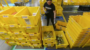 ARCHIVO – Una empleada escanea mercancías entrantes en una estación de recepción del centro de envío de pedidos OXR1 de Amazon en Oxnard, California, el 21 de agosto de 2024. (AP Foto/Damian Dovarganes, Archivo)