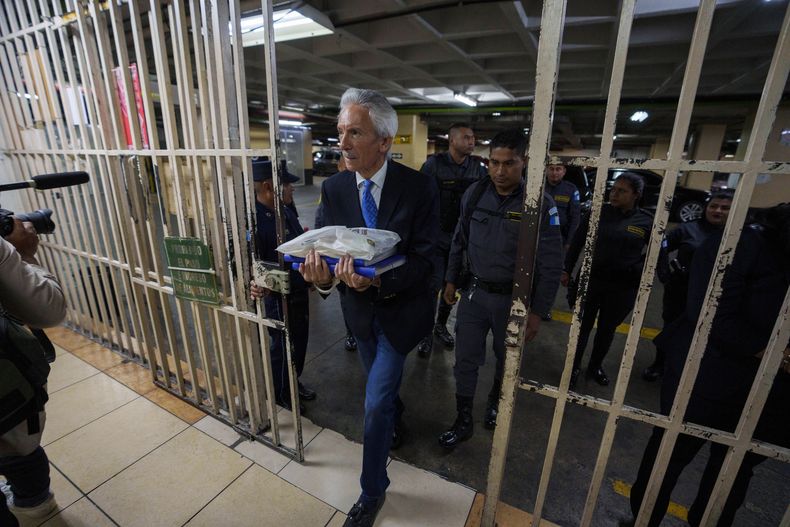 El periodista José Rubén Zamora, con esposas, es escoltado por la policía hacia la corte para una audiencia relacionada con su juicio por presunto lavado de dinero y otros cargos en Ciudad de Guatemala, el martes 30 de mayo de 2023. (AP Foto/Moisés Castillo)