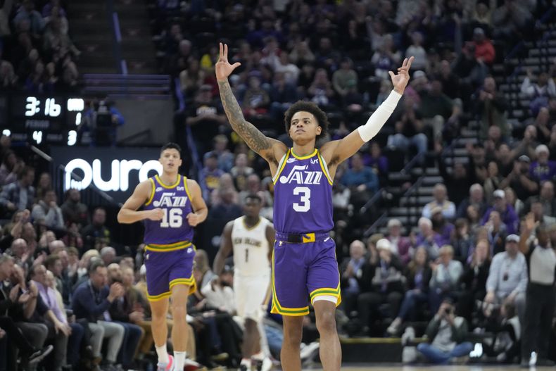 Keyonte George (3), del Jazz de Utah, reacciona después de que su compañero Simone Fontecchio (16) embocó un triple en contra de los Pelicans de Nueva Orleans, durante la segunda mitad del juego de baloncesto de la NBA, el lunes 27 de noviembre de 2023, en Salt Lake City. (AP Foto/Rick Bowmer)