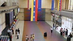 Un grupo de viajeros espera en la sala principal del Aeropuerto Internacional Simón Bolívar de Maiquetia, en esa localidad de Venezuela, el domingo 23 de noviembre de 2025, después de que varias aerolíneas internacionales cancelaran vuelos tras la advertencia de la Administración Federal de Aviación de Estados Unidos sobre una situación de riesgo en el espacio aéreo venezolano. (AP Foto/Ariana Cubillos)