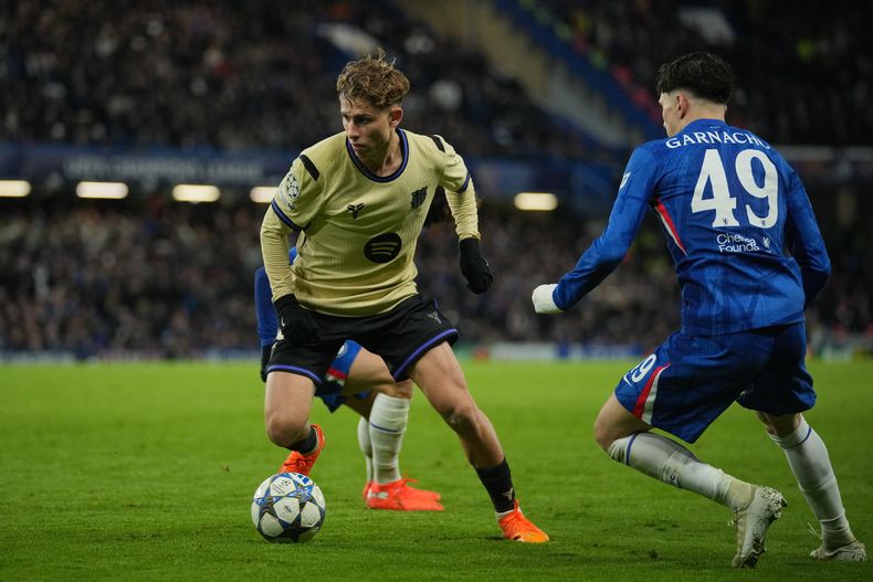 Fermín Lopez del Barcelona avanza con el balón superando al argentino Alejandro Garnacho del Chelsea en el encuentro de la Liga de Campeones el martes 25 de noviembre del 2025. (AP Foto/Kin Cheung)