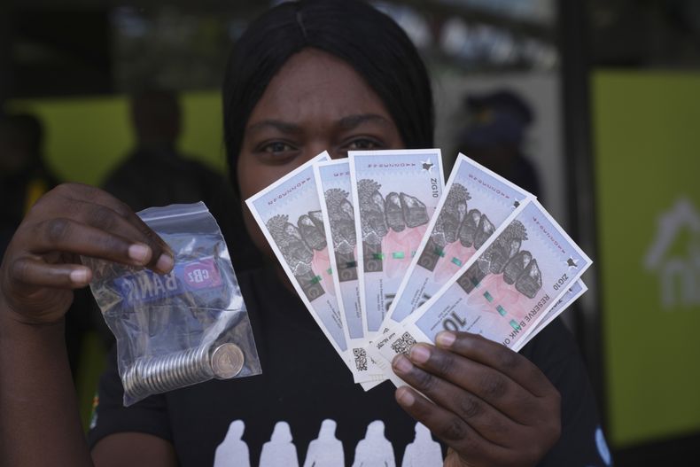 Una mujer con billetes de la nueva moneda zimbabuense, el ZiG, en Harare, Zimbabue, el 30 de abril de 2024. (Foto AP/Tsvangirayi Mukwazhi)