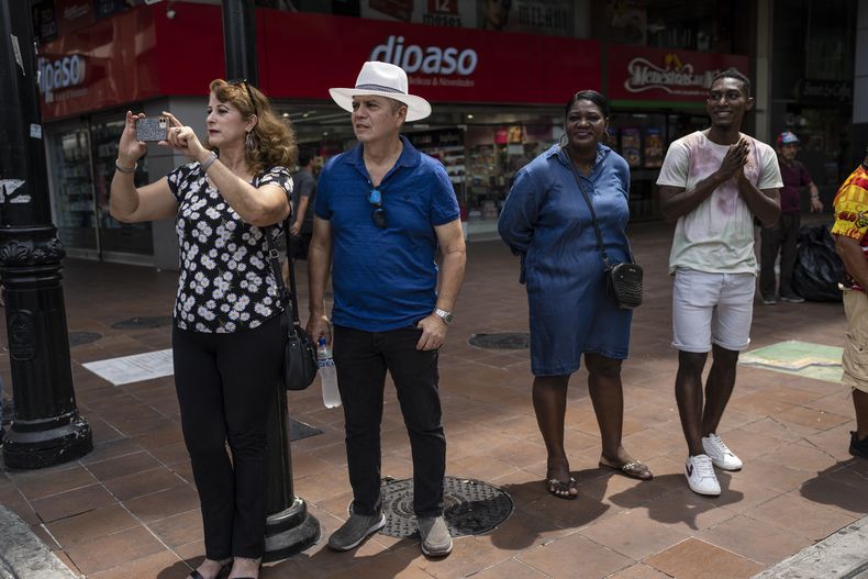 Varias personas observan a una banda de música estudiantil durante un desfile para conmemorar la independencia de la ciudad de Guayaquil, Ecuador, el 1 de octubre de 2023. (AP Foto/Rodrigo Abd)