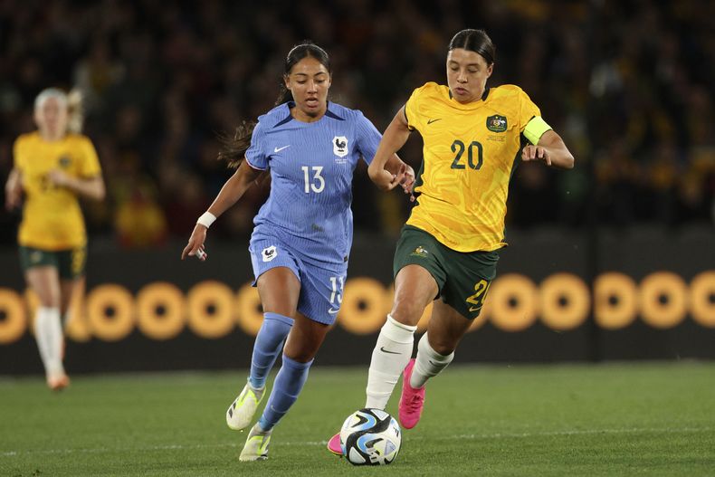 La australiana Sam Kerr avanza con el balón mientras la defiende la francesa Selma Bacha en un duelo amistoso en Melbourne el viernes 14 de julio del 2023. (AP Foto/Hamish Blair)