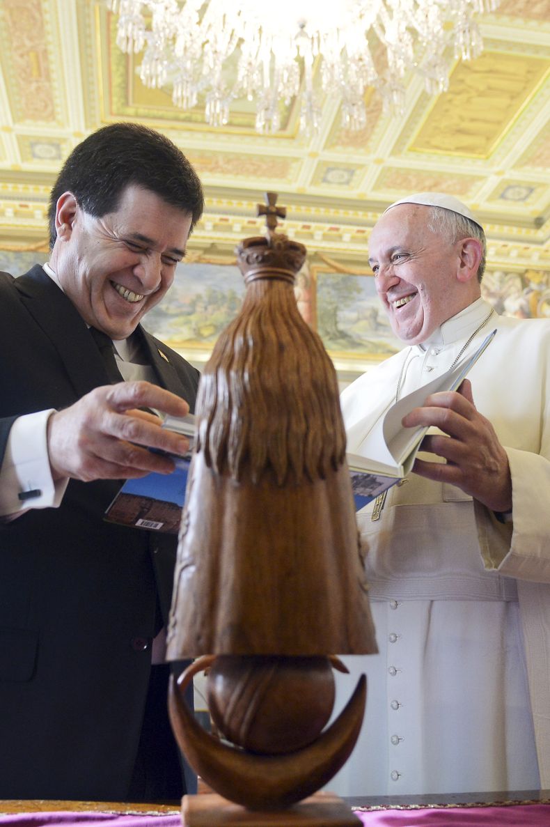El papa Francisco, derecha, sonr&iacute;e junto con el presidente paraguayo Horacio Cartes mientras intercambian regalos durante una audiencia privada en el Vaticano, el lunes 25 de noviembre de 2013. (Foto AP/Vincenzo Pinto, pool)