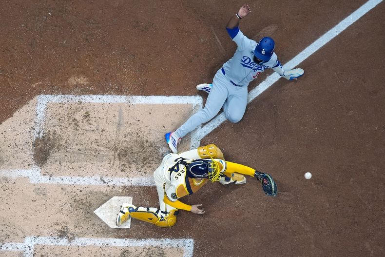 Teoscar Hernández de los Dodgers de Los Ángeles es sacado out en el plato por el receptor William Contreras de los Cerveceros de Milwaukee en el primer juego de la Serie de Campeonato de la Liga Nacional, el lunes 13 de octubre de 2025, en Milwaukee. (AP Foto/Morry Gash)