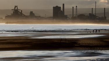 ARCHIVO – Varias personas pasean a sus perros en la playa, con la planta de acero Redcar en el fondo, en Hartlepool, Inglaterra, el 12 de noviembre de 2019. (AP Foto/Frank Augstein, Archivo)