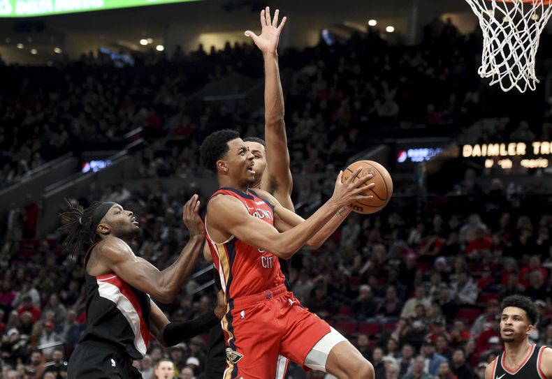 Trey Murphy III, base de los Pelicans de Nueva Orleáns, avanza a la canasta frente a Jerami Grant, de los Trail Blazers de Portland, en el partido del sábado 10 de febrero de 2024 (AP Foto/Steve Dykes)
