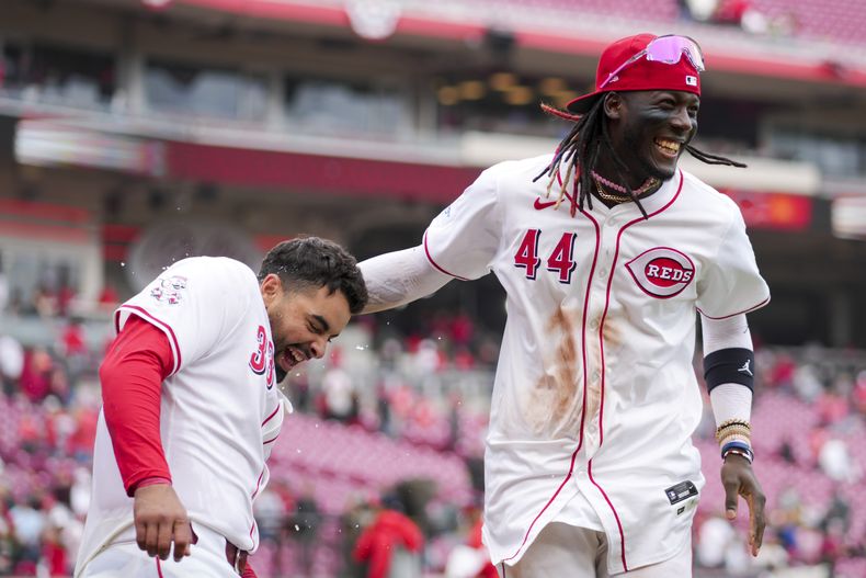 Christian Encarnacion-Strand, izquierda, de los Rojos de Cincinnati, celebra con su compañero Elly De La Cruz después de conectar el jonrón solitario de la victoria en la novena entrada del juego de béisbol en contra de los Nacionales de Washington, en Cincinnati, el domingo 31 de marzo de 2024. (AP Foto/Aaron Doster)
