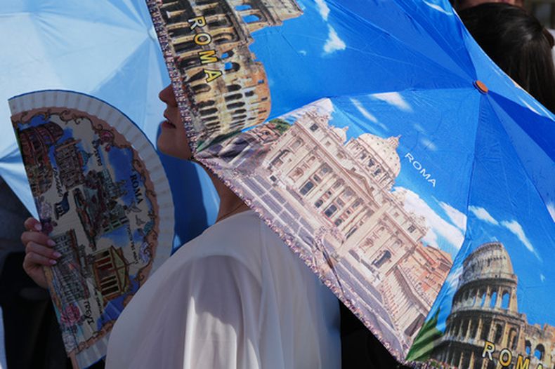 Una persona se refresca con abanico mientras espera a la audiencia general del papa León XIV en la plaza de San Pedro del Vaticano, el miércoles 24 de junio de 2026. (AP Foto/Alessandra Tarantino)