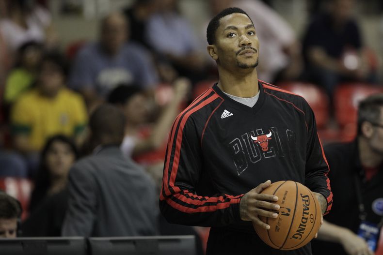 Derrick Rose de los Bulls de Chicago observa el calentamiento de sus compa&ntilde;eros previo a un partido de pretemporada contra los Wizards de Washington el s&aacute;bado 12 de octubre de 2013. (AP Foto/Felipe Dana)