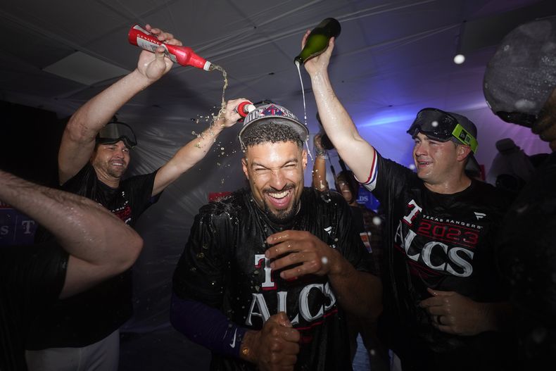 Marcus Semien, de los Rangers de Texas, festeja con sus compañeros luego de ganar la serie divisional a los Orioles de Baltimore, el martes 10 de octubre de 2023 (AP Foto/Julio Cortez)