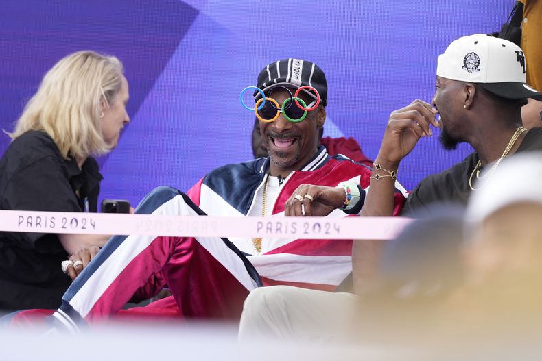 El artista estadounidense Snoop Dogg, en el centro, se sienta entre el público antes de la competencia de breaking en el Parque Urbano La Concorde en los Juegos Olímpicos de Verano de 2024, el viernes 9 de agosto de 2024, en París, Francia. (Foto AP/Frank Franklin)