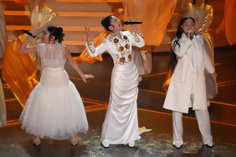 Rei Ami, EJAE y Audrey Nuna, de izquierda a derecha, interpretan Golden de K-Pop Demon Hunters durante la ceremonia de los Oscar el domingo 15 de marzo de 2026 en el Teatro Dolby de Los Ángeles. (Foto AP/Chris Pizzello)