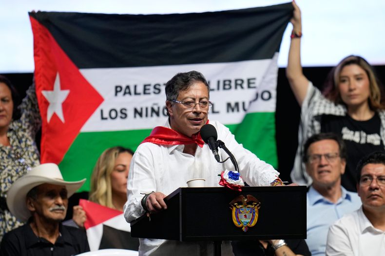 ARCHIVO - Partidarios del presidente colombiano Gustavo Petro sujetan una bandera palestina mientras Petro habla en un evento en Ibague, Colombia, el 3 de octubre del 2025. (Foto AP/ Fernando Vergara, Archivo)