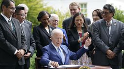 ARCHIVO - El presidente Joe Biden entrega un bolígrafo a la secretaria del Interior, Deb Haaland, mientras firma una proclamación en el jardín norte de la Casa Blanca en Washington, el 8 de octubre de 2021. (AP Foto/Susan Walsh, Archivo)